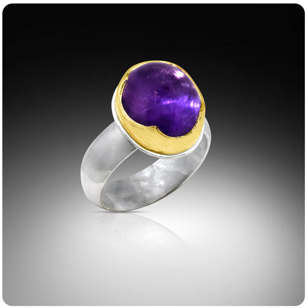 Ring with purple gemstone and gold accents on a gradient background