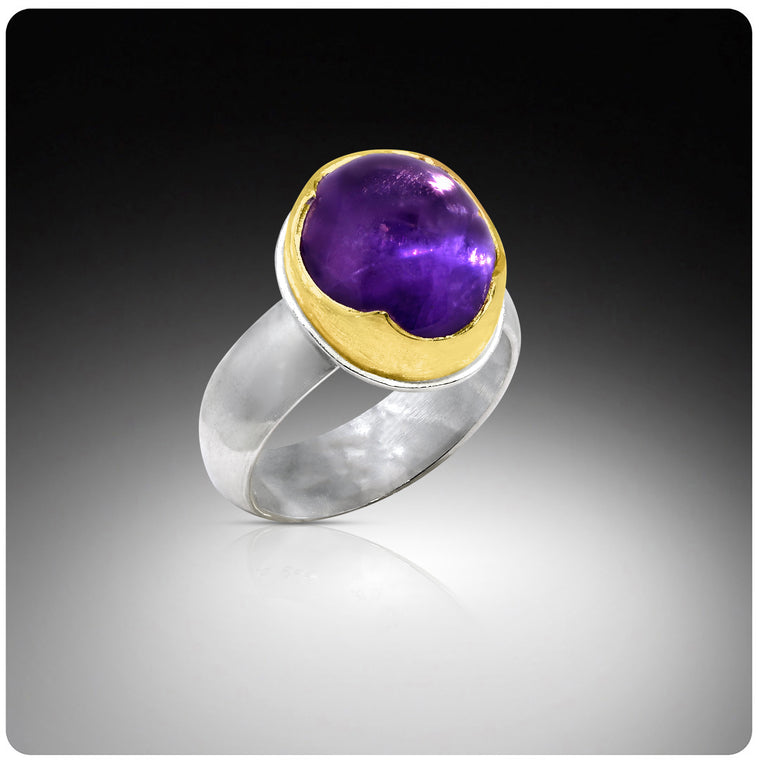 Ring with purple gemstone and gold accents on a gradient background