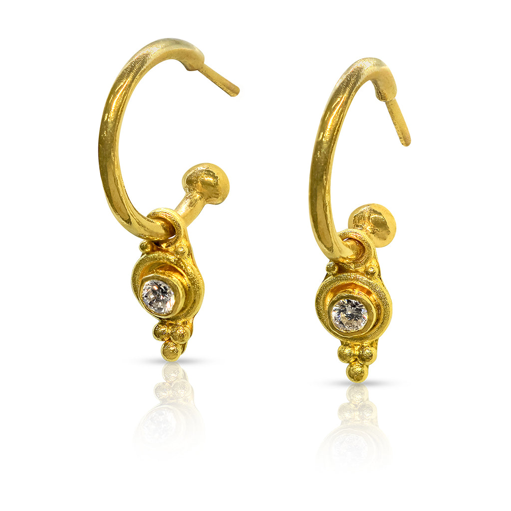 Gold hoop earrings with gemstones on a white background