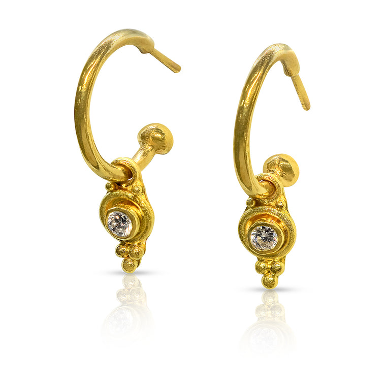 Gold hoop earrings with gemstones on a white background