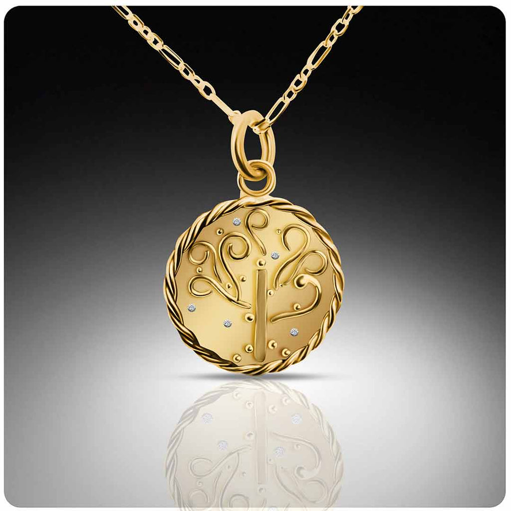 Gold pendant necklace with intricate tree of life design on a reflective surface